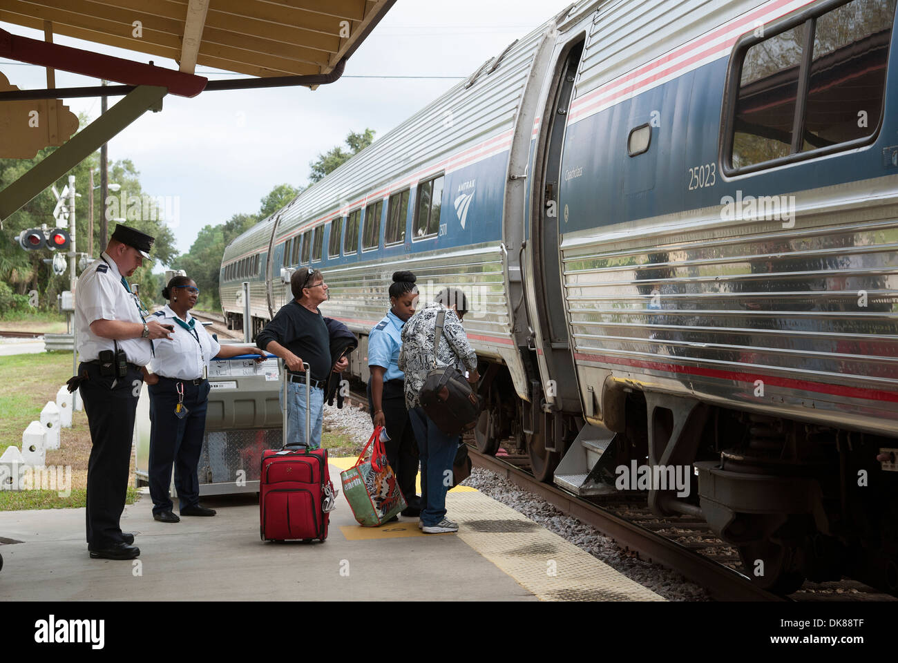 Eisenbahn Dirigent und Station Mitarbeiter unterstützen Passagiere an Bord einen Amtrak-Zug. DeLand Station Florida USA Stockfoto