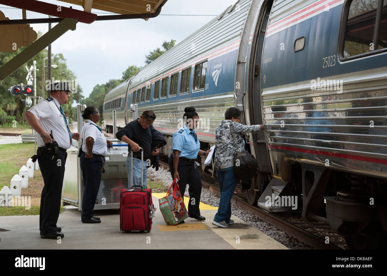 Eisenbahn Dirigent und Station Mitarbeiter unterstützen Passagiere an Bord einen Amtrak-Zug. DeLand Station Florida USA Stockfoto