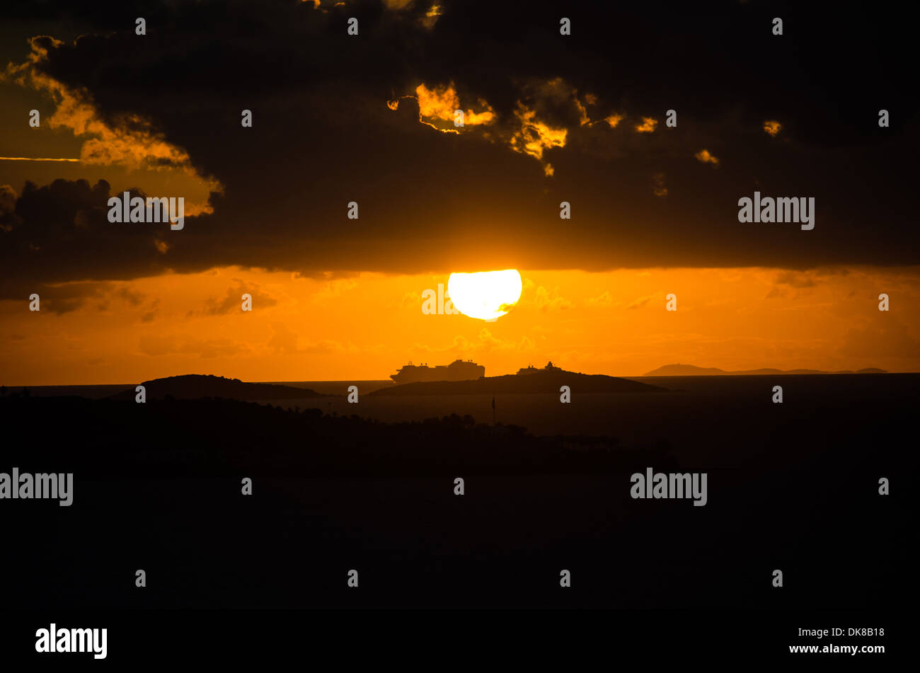 KARIBISCHES MEER – Ein dramatischer karibischer Sonnenuntergang färbt den Himmel in leuchtenden Orange- und Goldtönen. Stockfoto