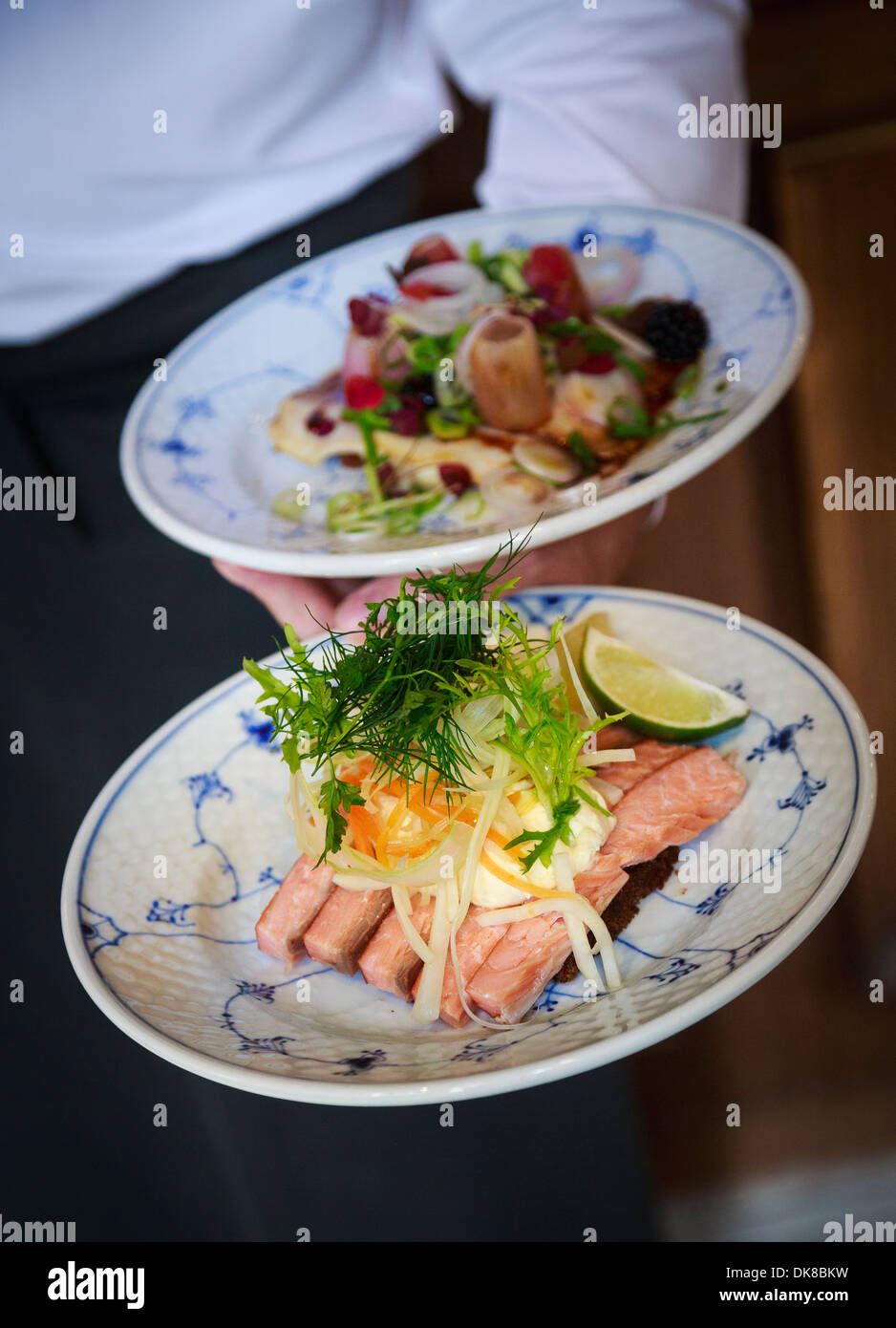 Hand, die zwei Platten von Smorrebrod im Restaurant Schonnemann serviert traditionelle dänische Gerichte, Kopenhagen, Dänemark Stockfoto
