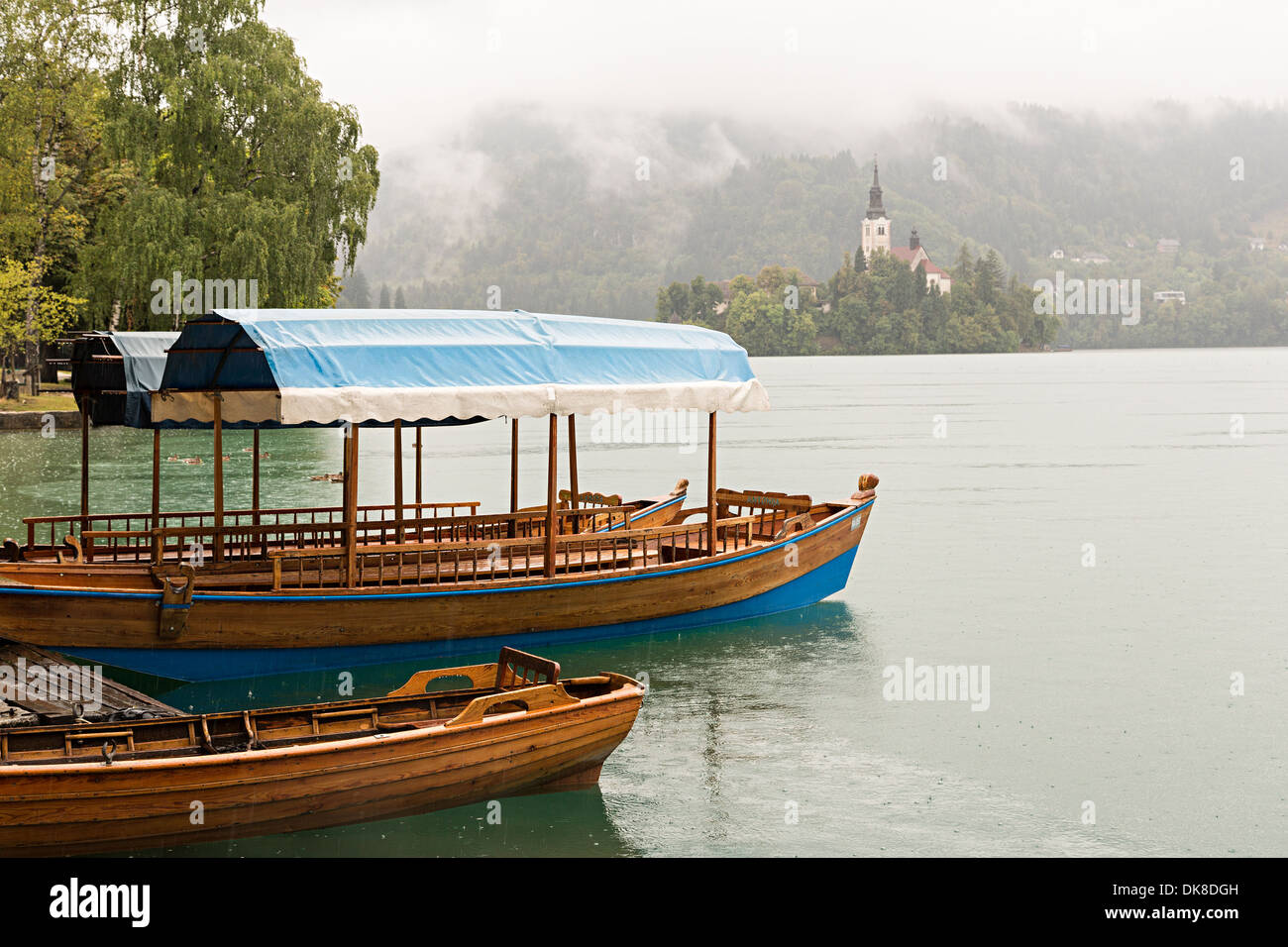 Boote auf dem See im Regen in Bled, Slowenien Stockfoto