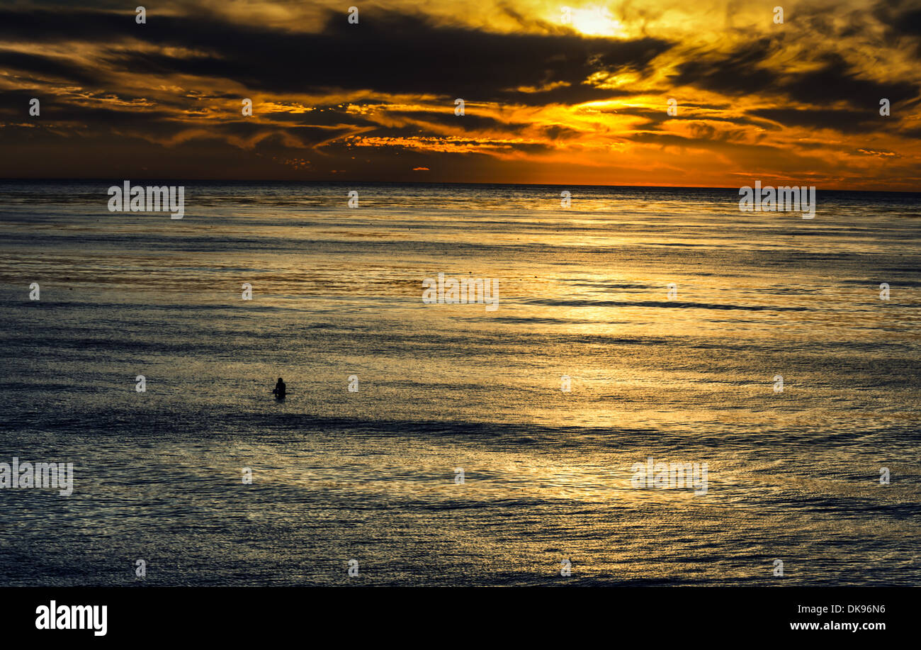Ein einsamer Surfer im Pazifischen Ozean während des Sonnenuntergangs. Von Sunset Cliffs Natural Park, San Diego, Kalifornien, USA fotografiert. Stockfoto