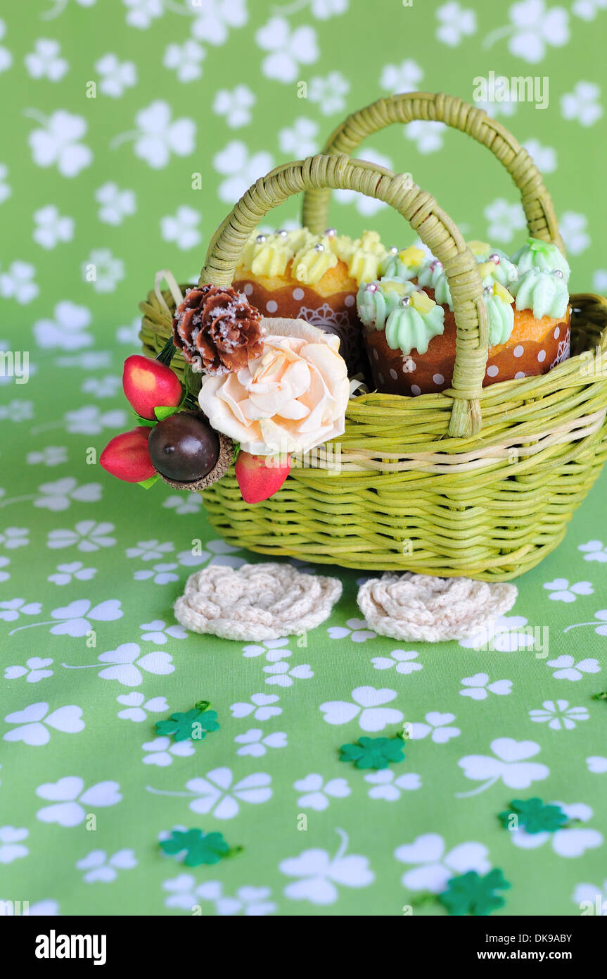 Tasse Kuchen und Blumen in einem Korb Stockfoto