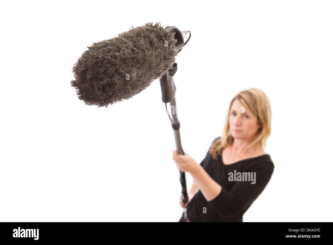 Frau mit einem Mikrofonarm vor einem weißen Hintergrund. Selektiven Fokus auf die pelzigen Mikrofon-Windschutz. Stockfoto