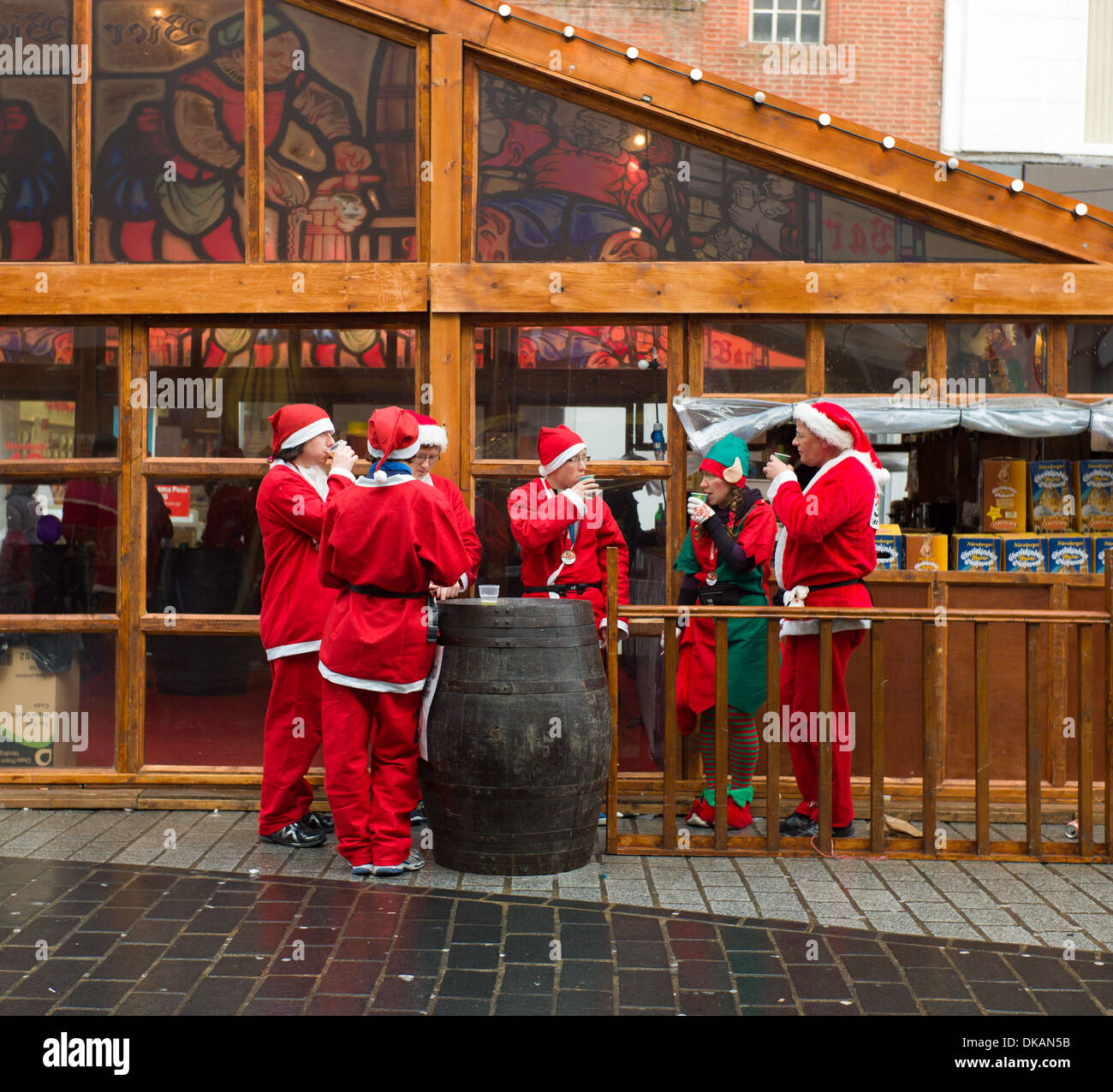 Nächstenliebe-Santa-Lauf in Liverpool Läufer entspannen auf dem Weihnachtsmarkt mit einem Bier Stockfoto