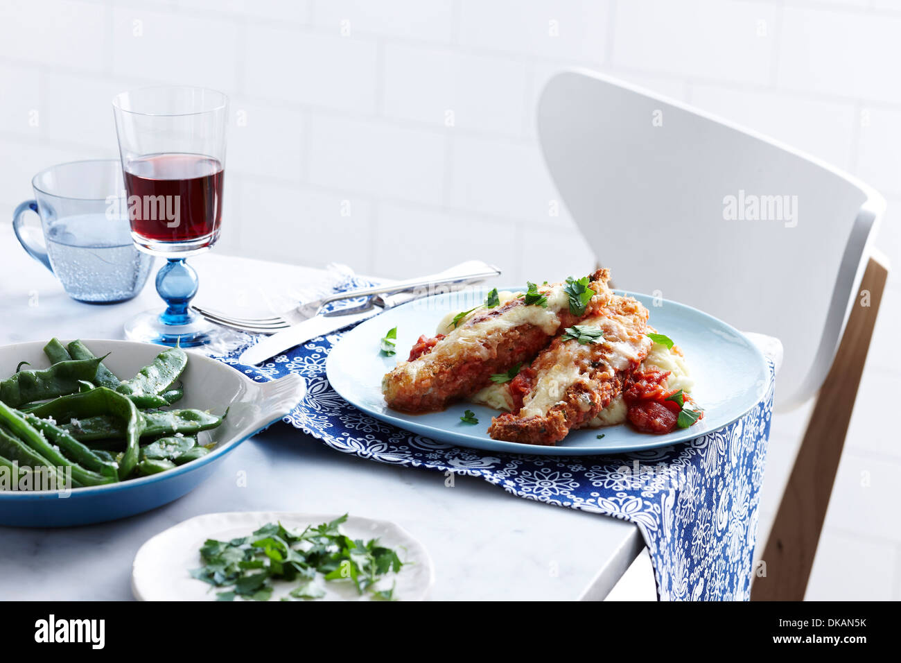 Mahlzeit mit Schale Chicken parmigiana und grüne Bohnen Stockfoto