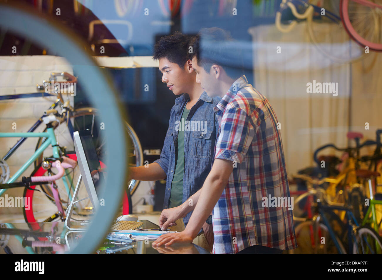 Zwei junge Männer im Fahrradladen mit computer Stockfoto