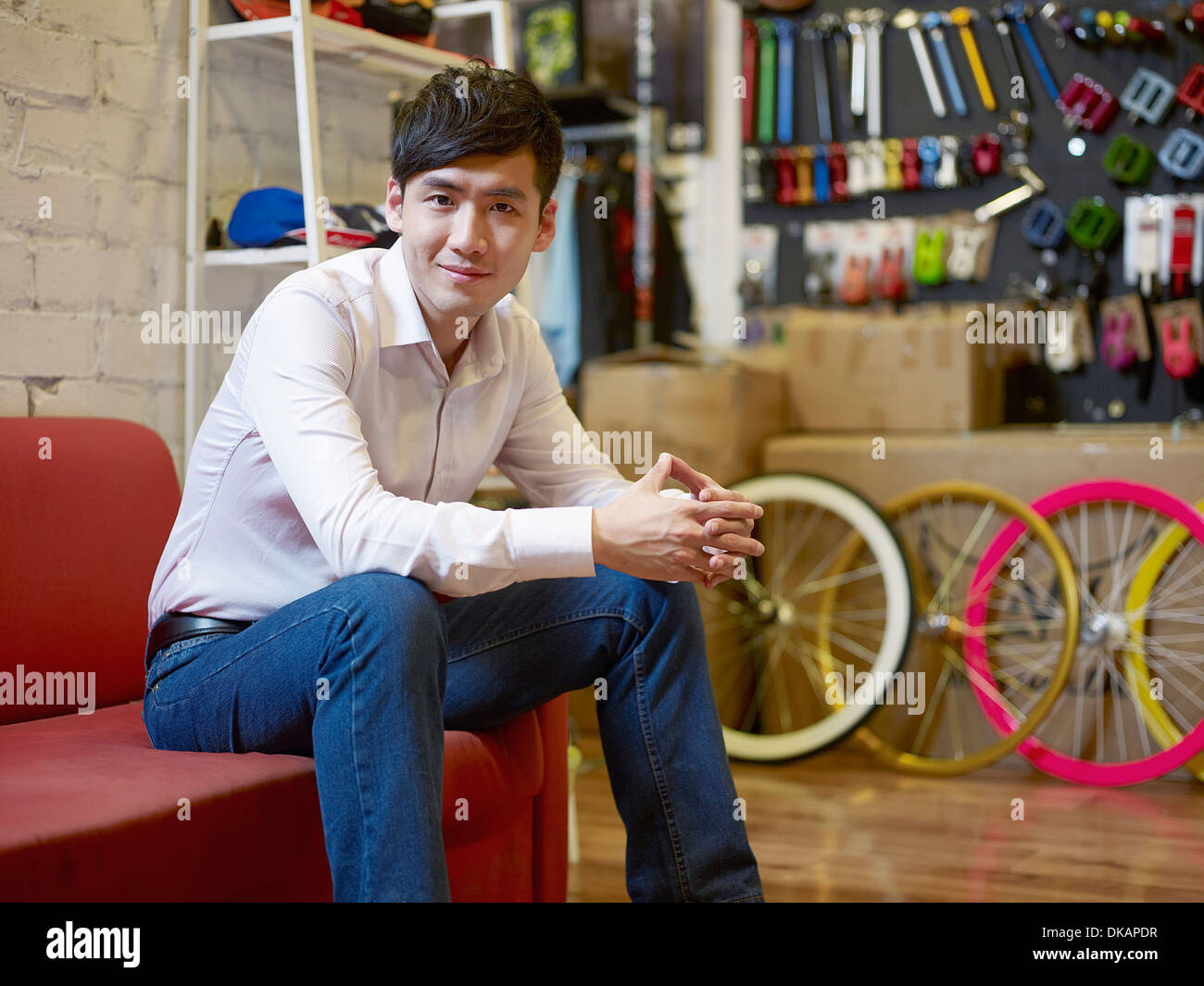 Porträt der junge Mann sitzt im Bike-shop Stockfoto