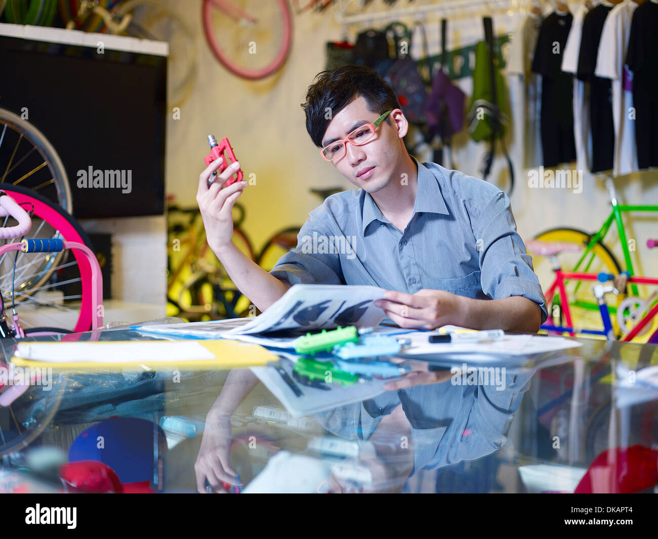 Junger Mann Prüfung Fahrrad Teil im Bike-shop Stockfoto
