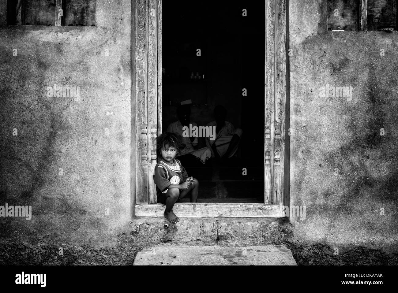 Indische Bauerndorf Junge sitzt in seinem Haus Tür. Andhra Pradesh, Indien. Monochrom Stockfoto