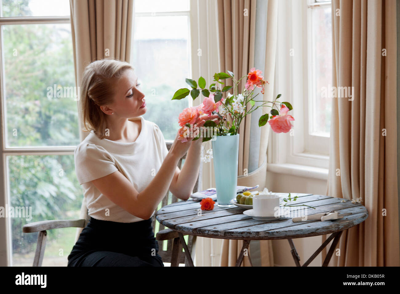 Frau, die Vermittlung von Rosen in vase Stockfoto