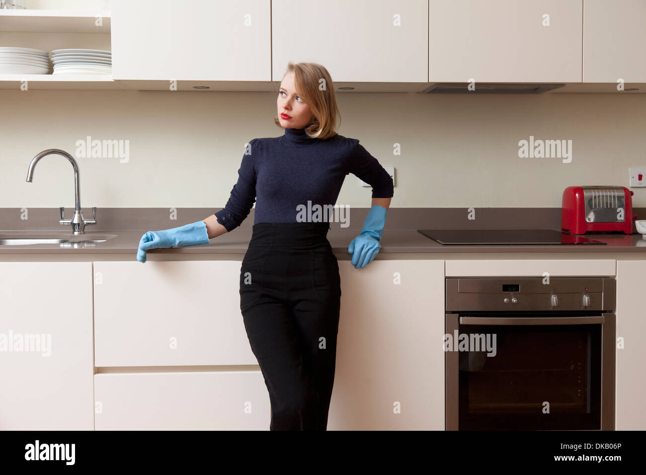 Frau gelehnt Küchenschrank Stockfoto