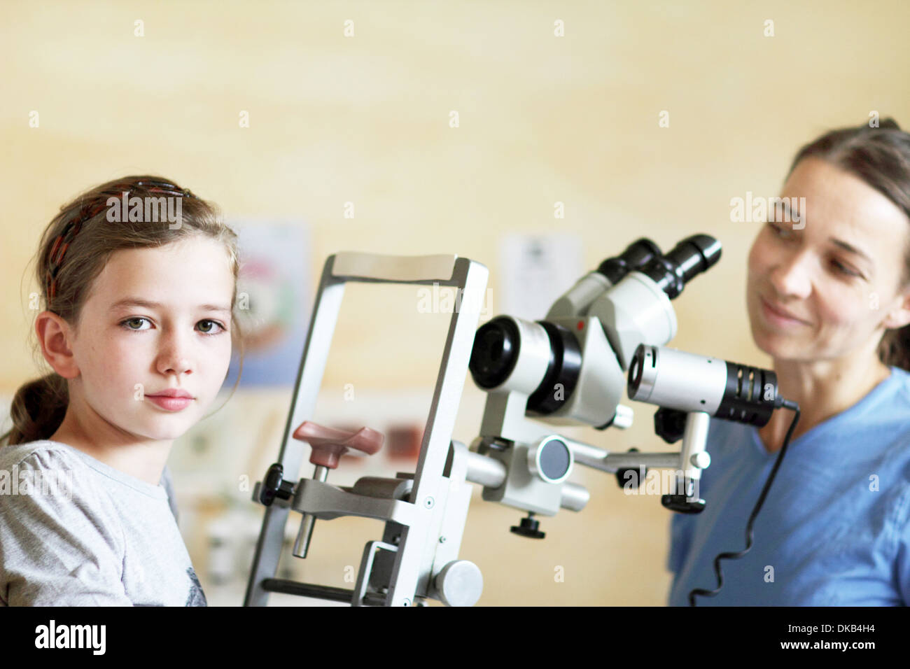 Optiker, die Augen des Mädchens untersuchen wird vorbereitet Stockfoto