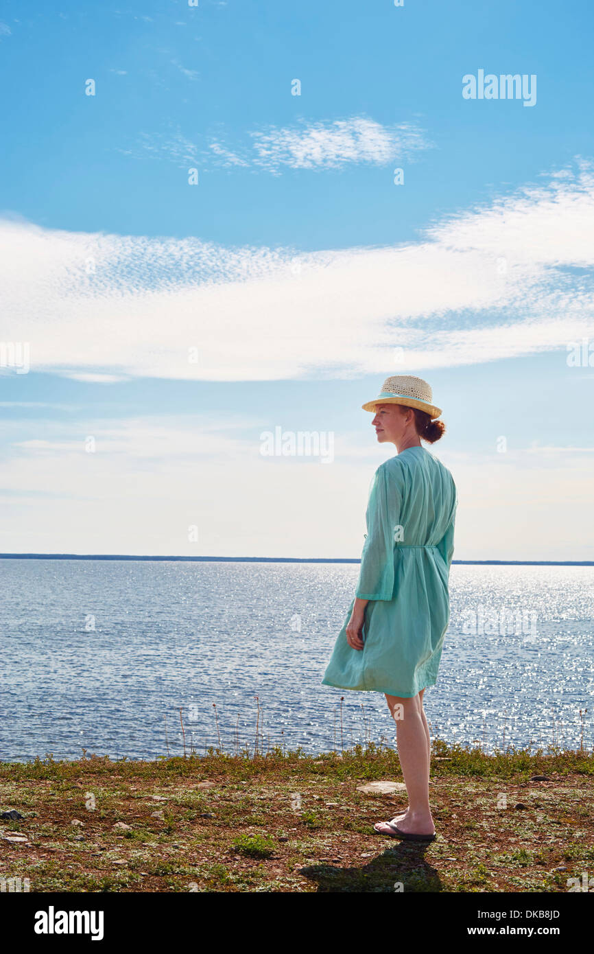 Mitte Erwachsene Frau, die auf dem Seeweg im grünen Kleid, Eggergrund, Schweden Stockfoto