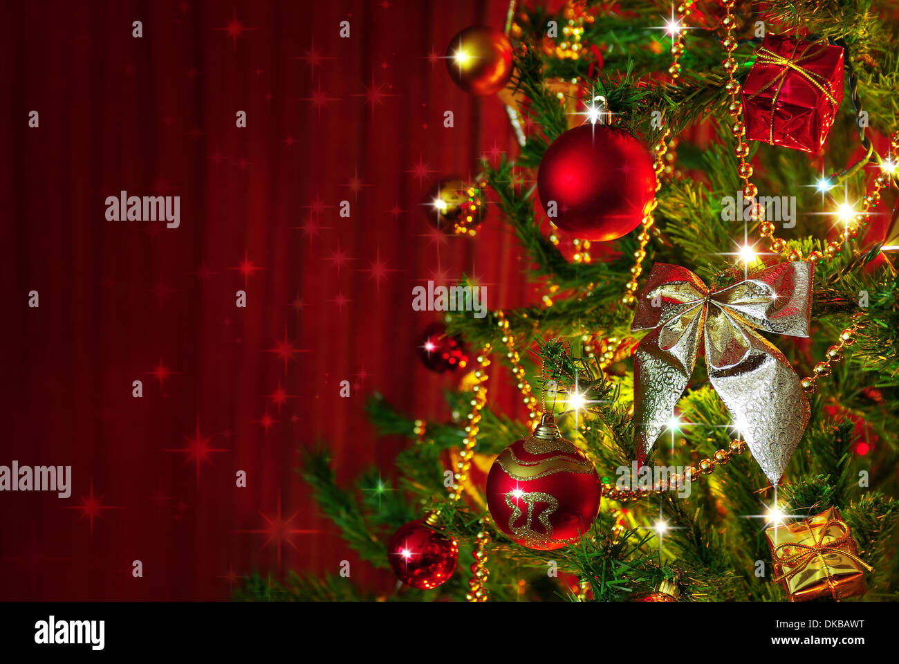 Detail eines Weihnachtsbaumes neben roten Vorhänge mit Textfreiraum Stockfoto