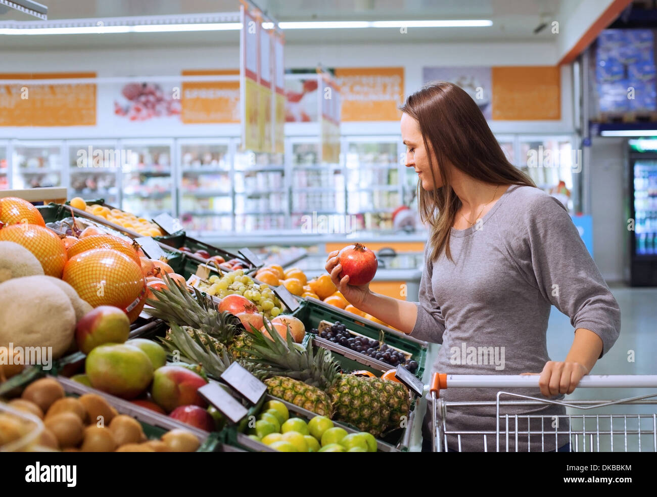 junge Frau im Supermarkt Obst auswählen Stockfoto