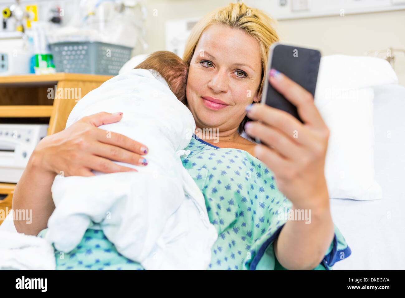Patienten, die unter Selbstbildnis mit Babygirl durch Smart-Phone Stockfoto