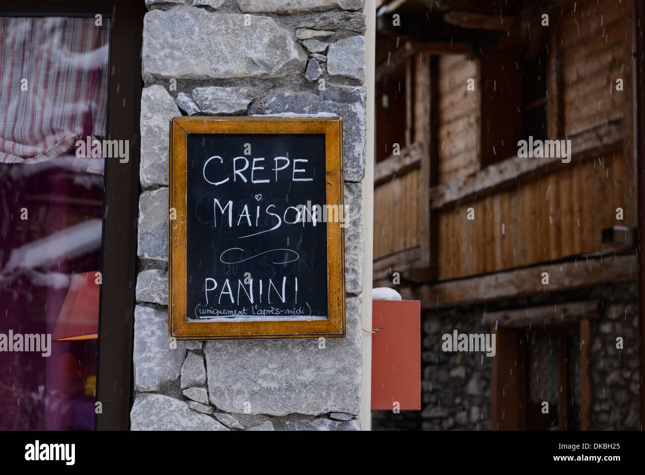 Outdoor-Blackboard anmelden eine Steinmauer mit einem rustikalen Holzhaus im Hintergrund Stockfoto