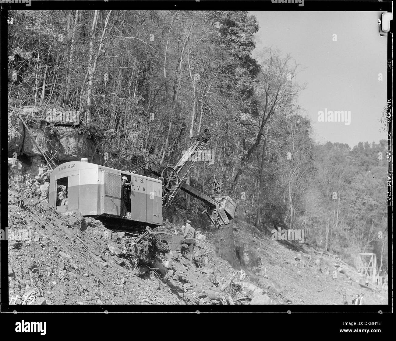 Eine Motorschaufel wird für den Bau einer Fahrbahn am Hang am Norris-Staudamm verwendet, die Teil des Bauprojekts des Staudamms ist. Stockfoto Eine Motorschaufel wird für den Bau einer Fahrbahn am Hang am Norris-Staudamm verwendet, die Teil des Bauprojekts des Staudamms ist. Stockfoto