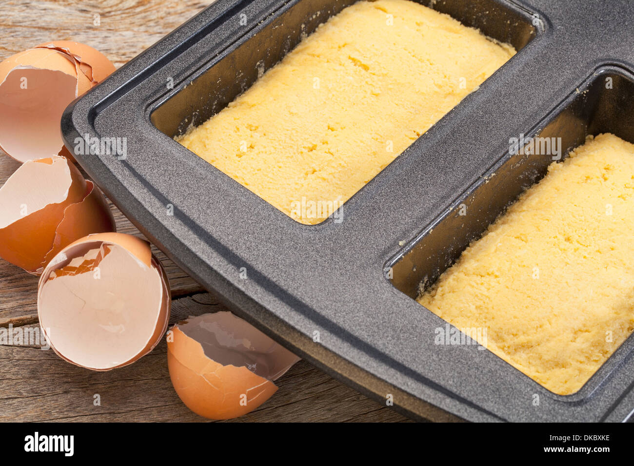 Teig für Kokosnuss missachten Gluten Brot in einer Backform mit gebrochenen Eierschalen Stockfoto