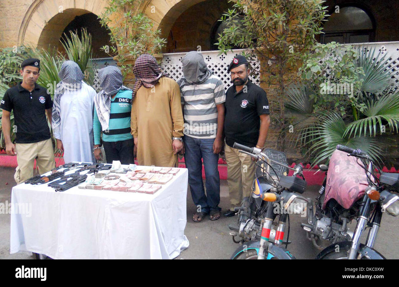 Polizei verhaftet zeigt bank Räuber und wiederhergestellten Waffe und Währung aus, während einer Pressekonferenz am Hauptsitz SIU Polizei in Karachi auf Mittwoch, 4. Dezember 2013. Während Raubüberfälle in sieben Banken von Karachi auf Mittwoch, 4. Dezember 2013 geplündert festgenommene Verbrecher mehr als 10 Millionen Rupien. Stockfoto