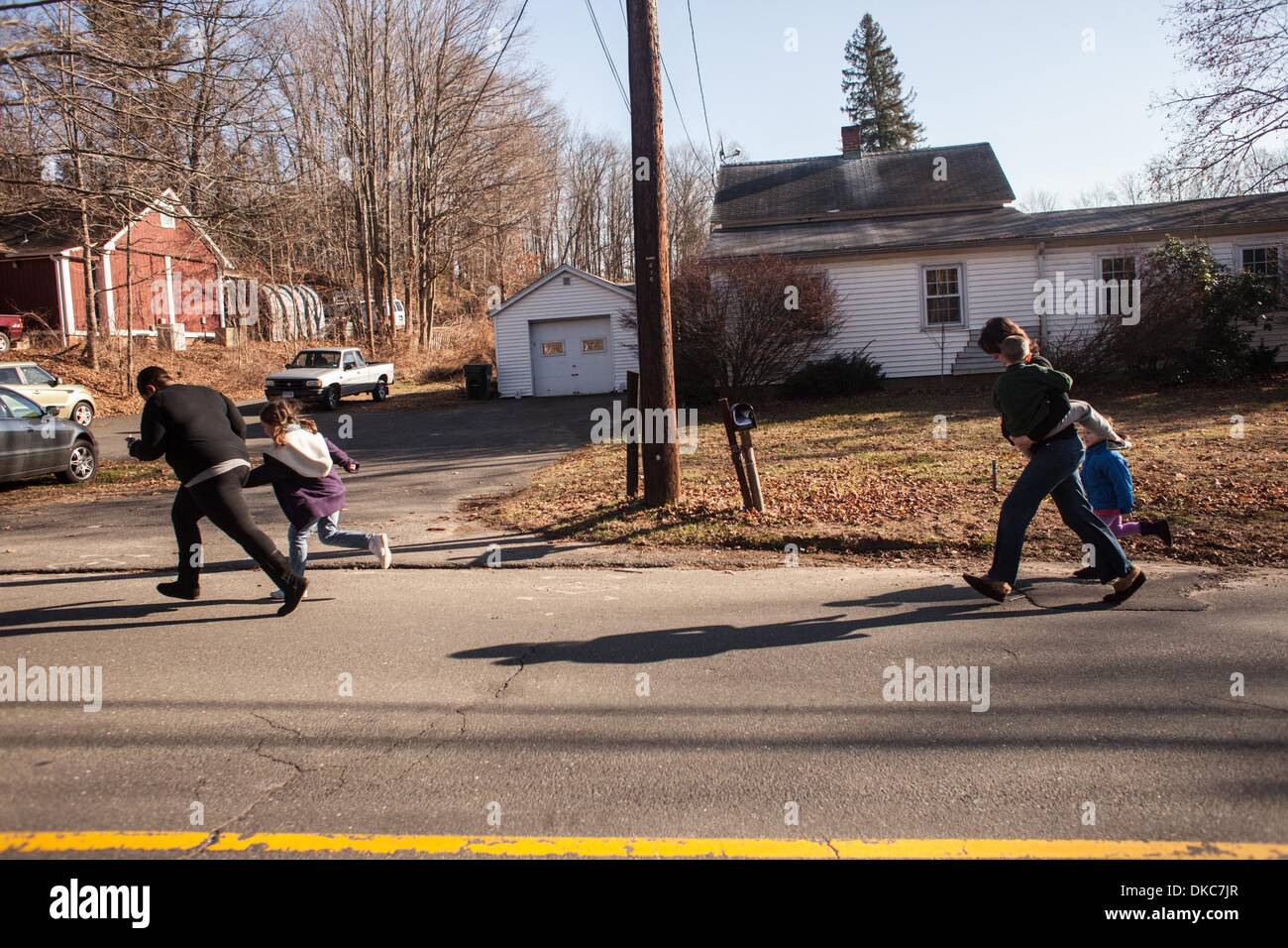 Newtown, Connecticut, USA. 14. Dezember 2012. Eltern läuft mit Kindern von der Schule entfernt. 20-Year-Old Adam Lanza Schuss tödlich zwanzig Kinder und sechs Erwachsene Mitarbeiter in einem Massenmord an Sandy Hook-Grundschule im Dorf von Sandy Hook in Newtown, Connecticut. Vor der Fahrt zur Schule, Lanza geschossen und tötete seine Mutter Nancy zu Hause Newtown. First Responder angekommen, beging er Selbstmord durch erschießen selbst in den Kopf. © Andrew Sullivan/ZUMA Wire/ZUMAPRESS.com/Alamy Live-Nachrichten Stockfoto