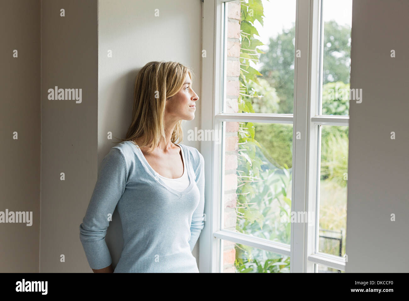 Porträt von Mitte Erwachsene Frau aus Fenster Stockfoto