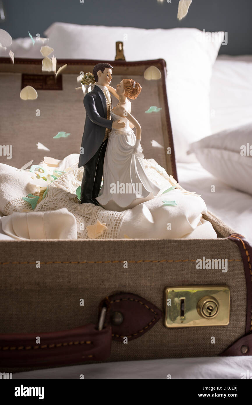 Offenen Koffer auf Bett mit Hochzeit Figurinen und Konfetti Stockfoto
