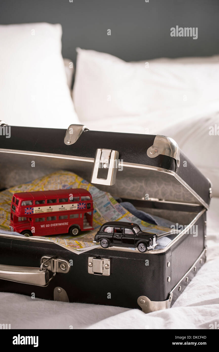Offenen Koffer auf Bett mit Spielzeug-London-Bus und Taxi Stockfoto