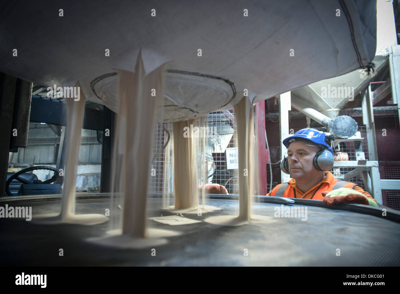 Arbeiter im harten Hut und Ohr Verteidiger Zirkonsand Inspektion Stockfoto