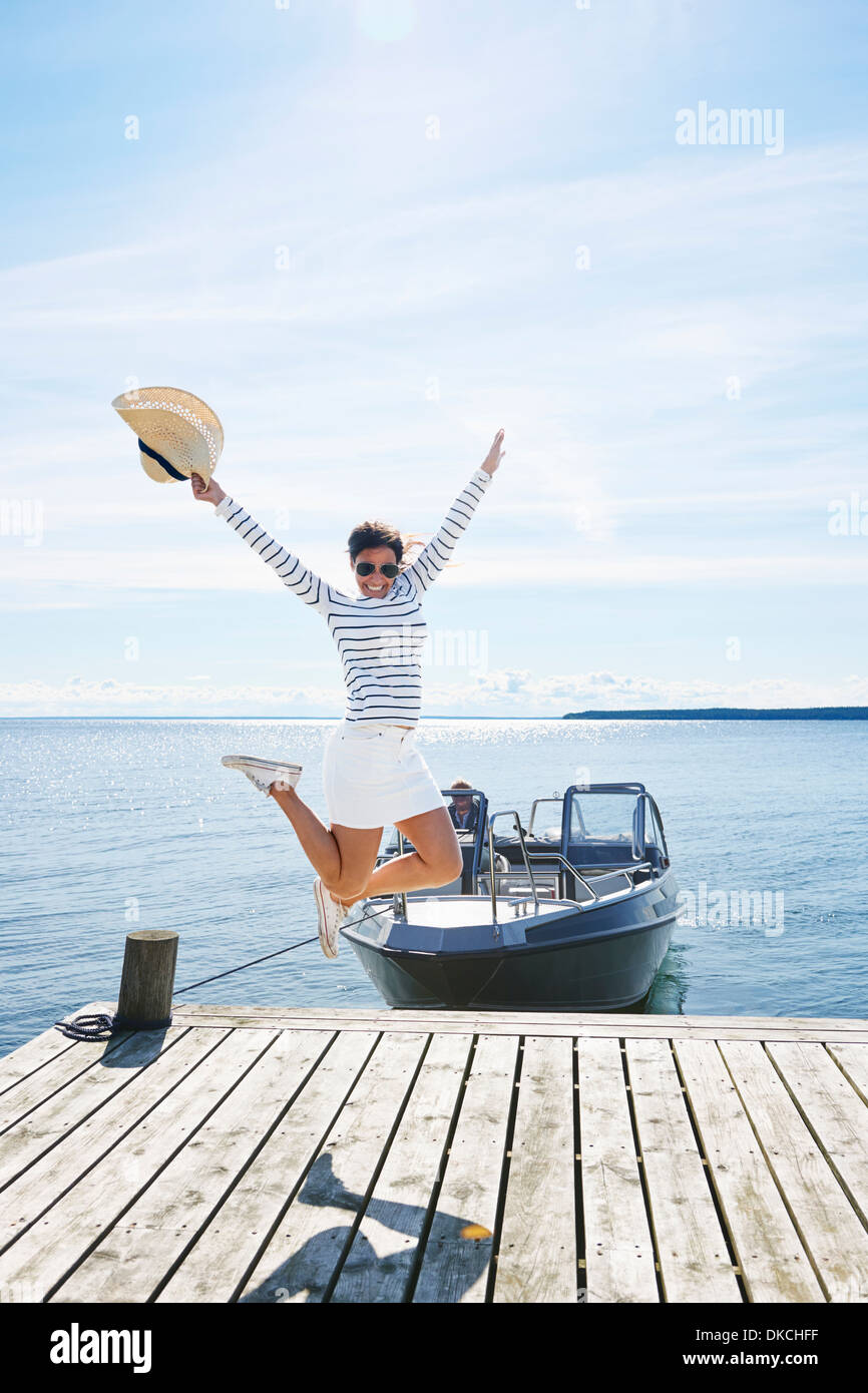 Junge Frau springt Luft am Pier, Hotels, Schweden Stockfoto