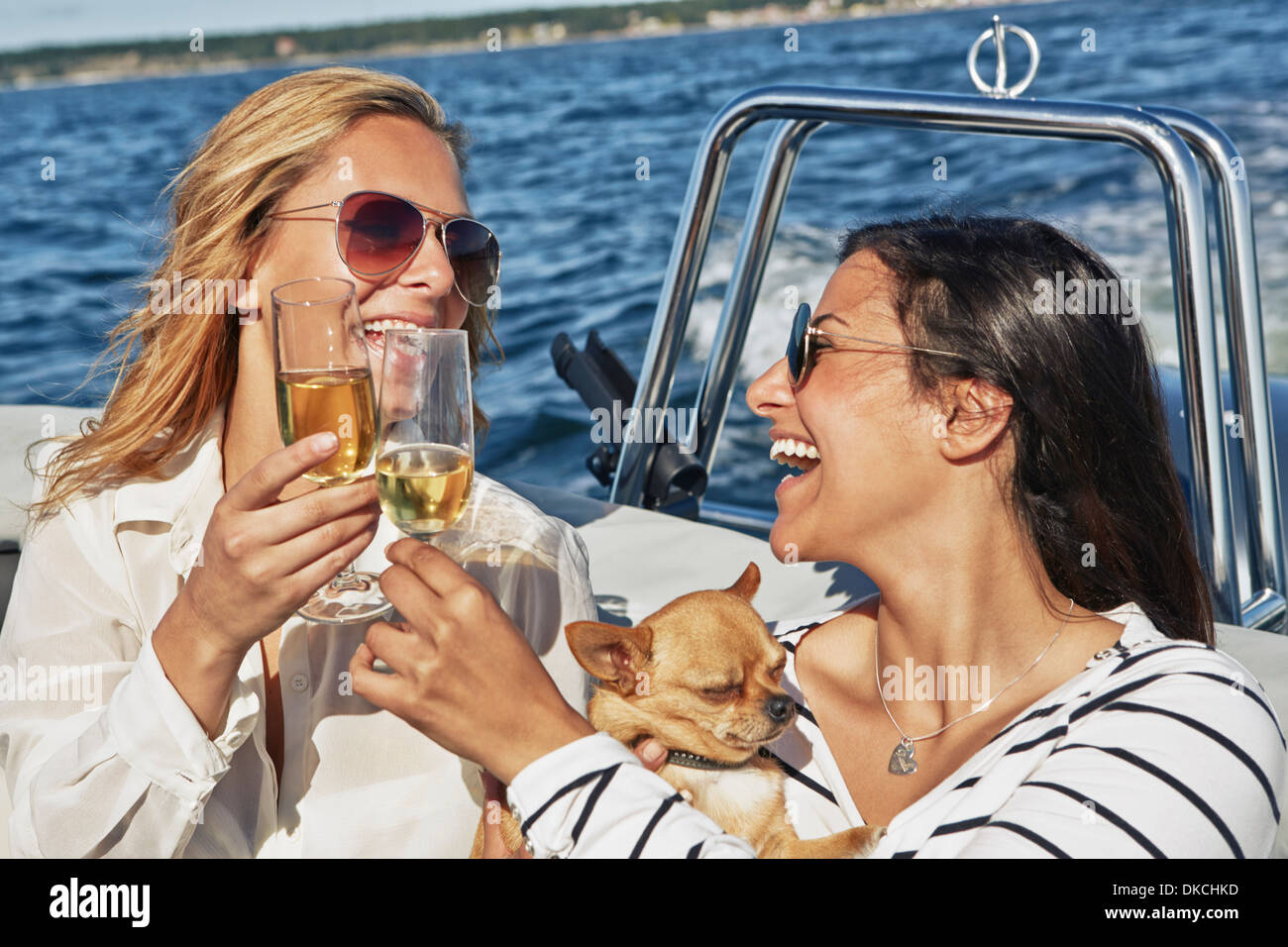 Zwei junge Frauen auf Boot Toasten Wein Stockfoto