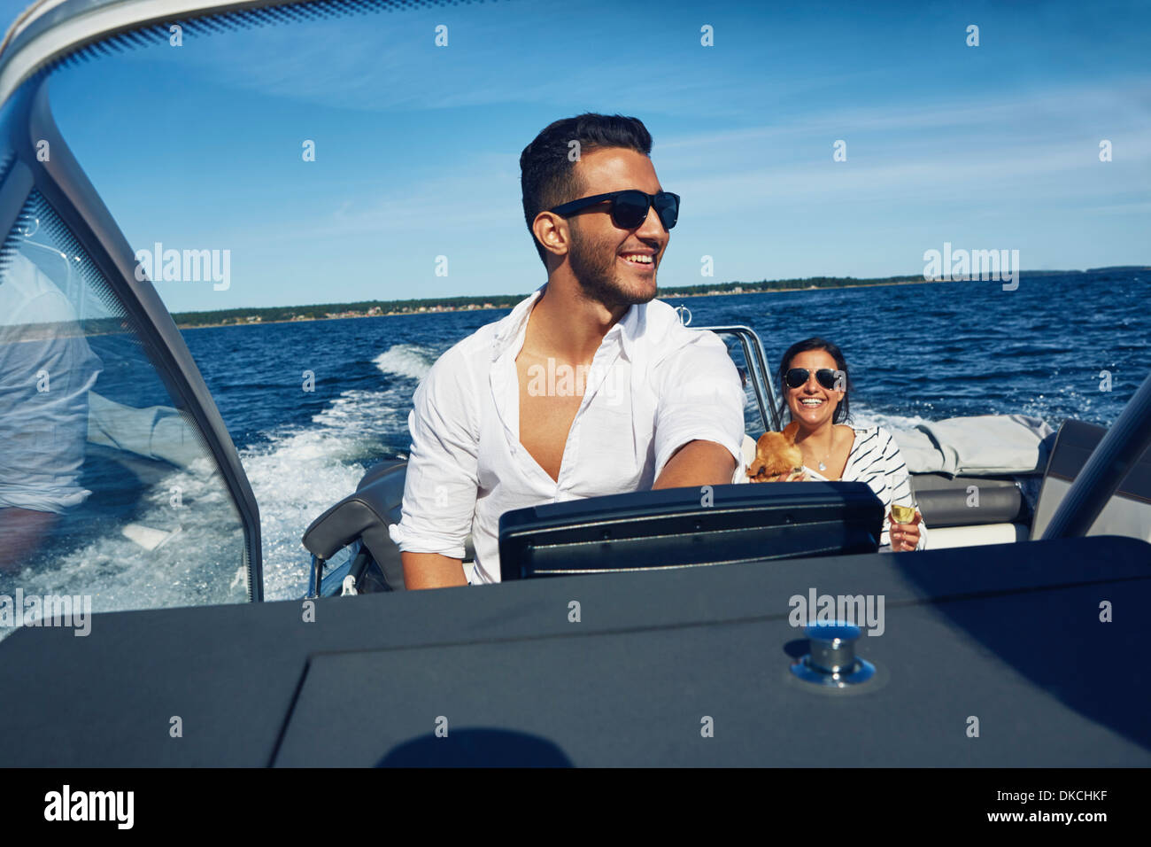 Junger Mann Lenkung Boot mit Frau im Hintergrund, Hotels, Schweden Stockfoto