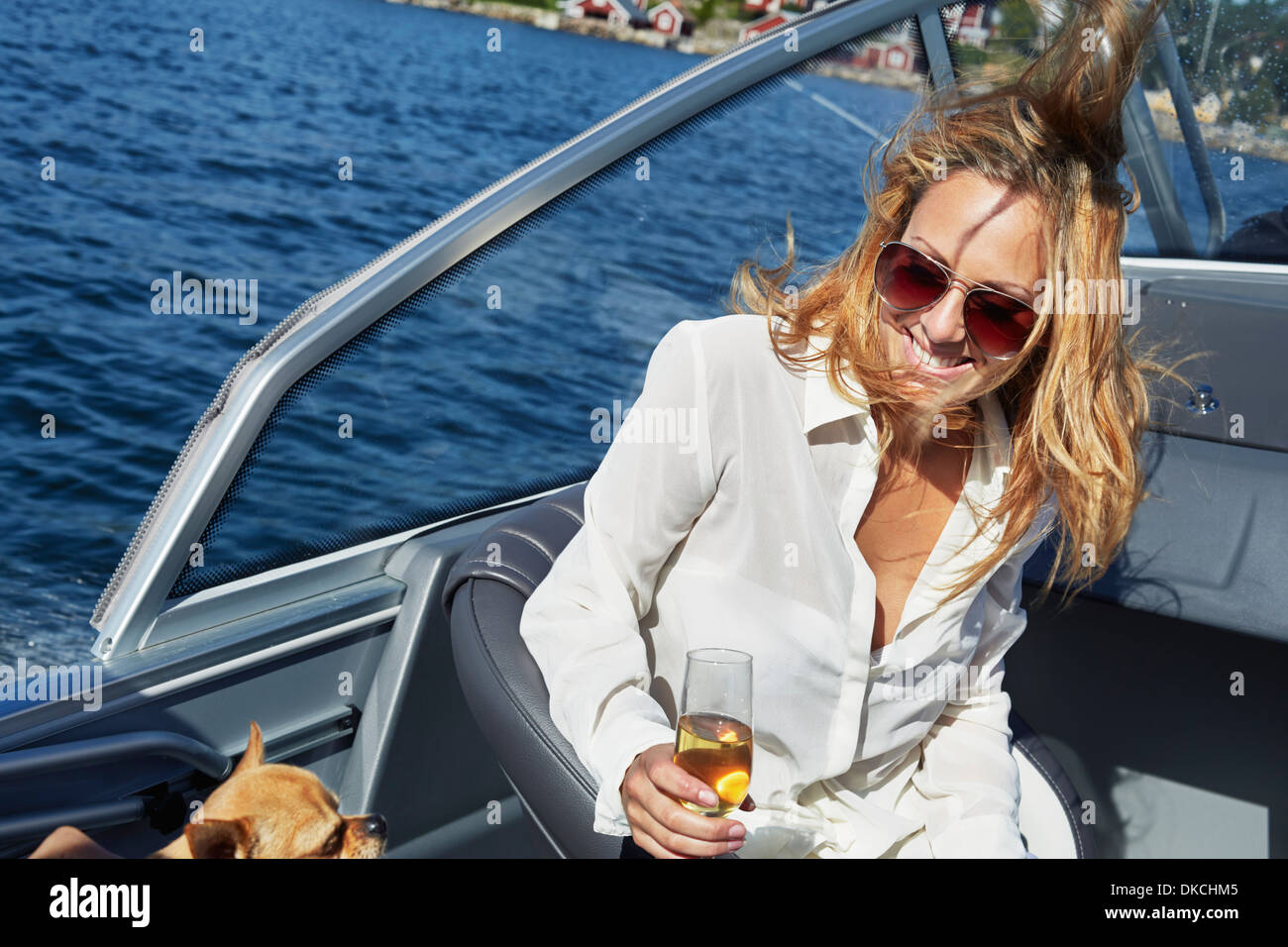 Junge Frau am Boot mit Glas Wein Stockfoto