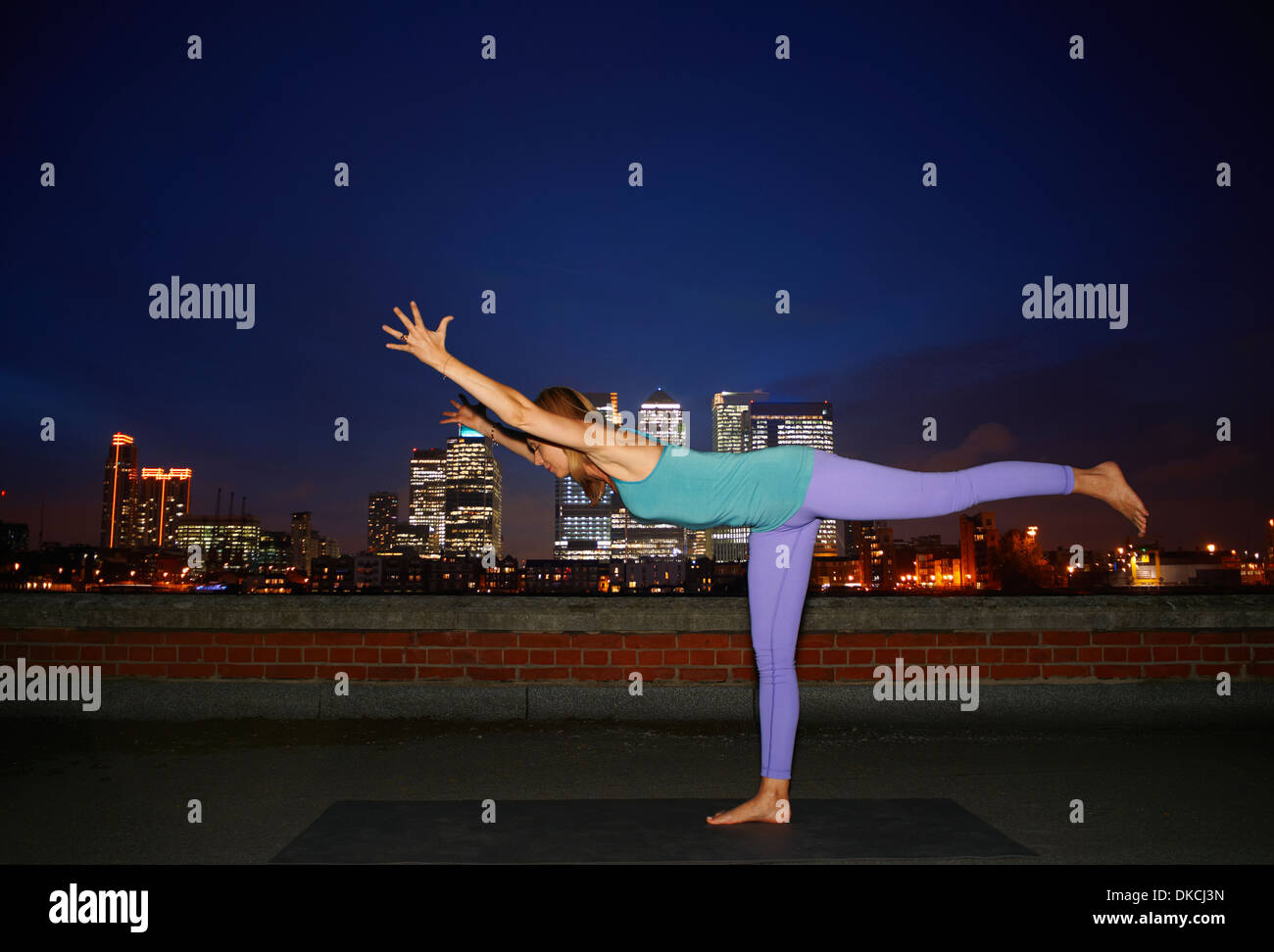 Mitte Erwachsene Frau praktizieren Yoga auf Stadt auf dem Dach Stockfoto