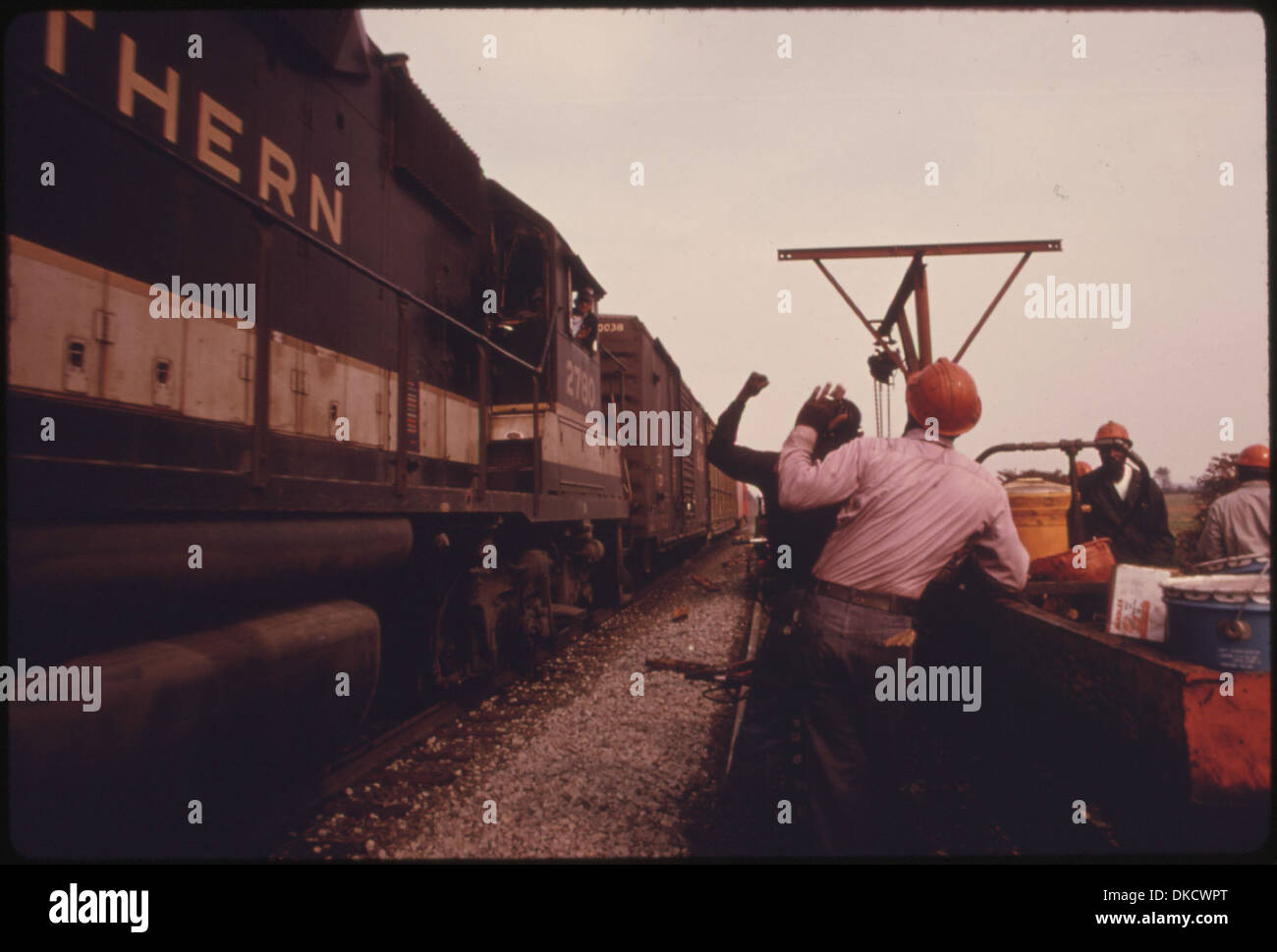 SÜDBAHN VORFAHRTSRECHT BELEGSCHAFT, UNTERBRICHT DIE ARBEIT, EINEN ZUG PASS AUF PARALLELEN TRACKS ZU LASSEN. AN EINEM GUTEN TAG WENN SIE... 556882 Stockfoto