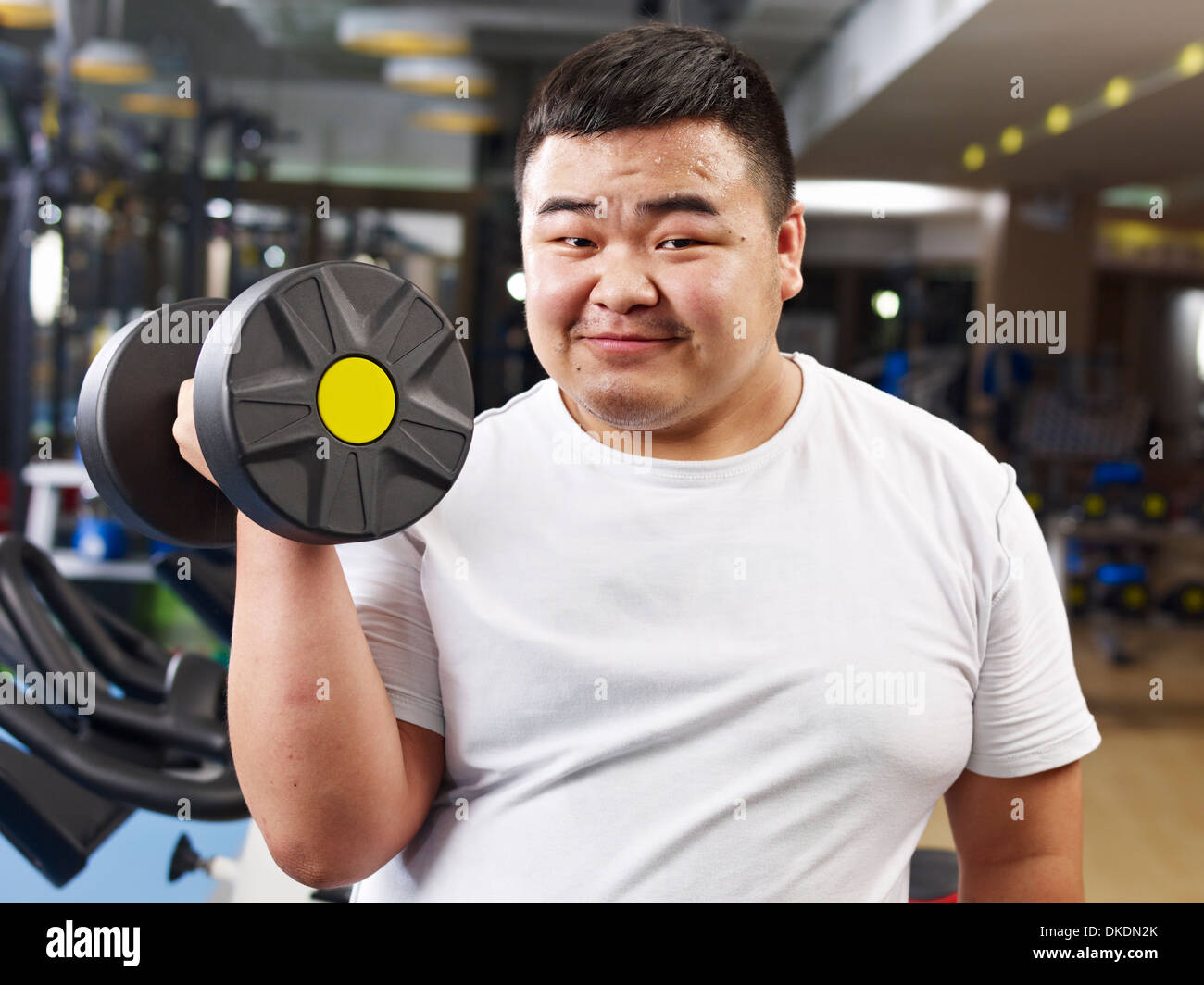 Übergewichtigen jungen Mann trainieren Sie im Fitness-Studio Stockfoto