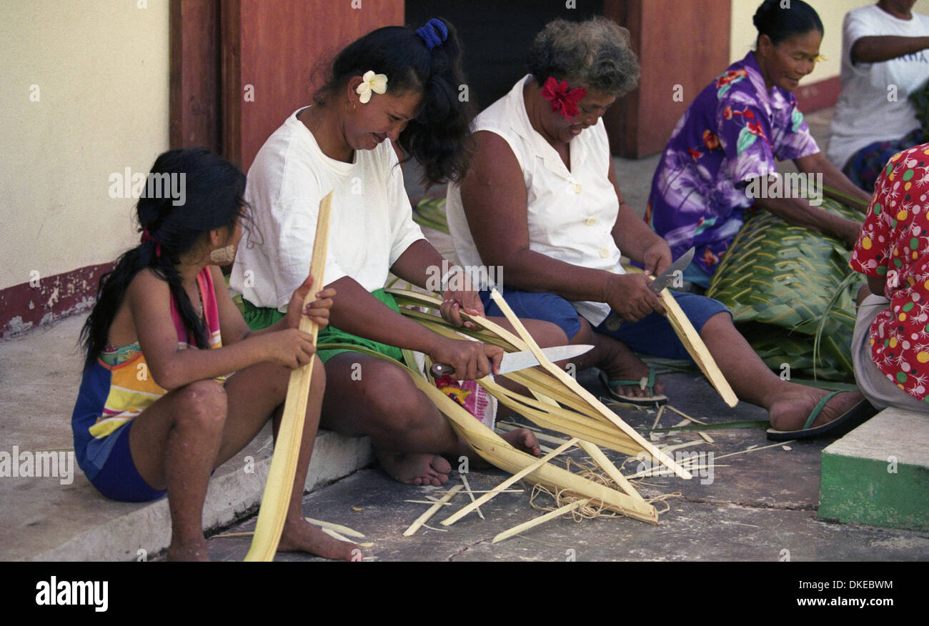 Eine Gruppe von polynesischen Frauen flechten Körbe mit Materialien aus der Kokospalme. Stockfoto