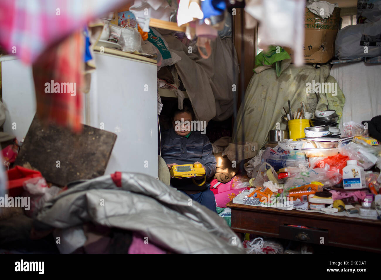 Peking, China. 2. Dezember 2013. YILAN ZHAO entspannt in ihrem Wohnzimmer. Zhao, lebt 58 Jahre alt, Nr. 264 Deshengmen Inner Street, Xicheng District. Zhao ist Analphabetin, hat keinen festen Arbeitsplatz oder Einkommen und ihr Ehemann ist deaktiviert und ans Bett gefesselt. Ihr Leben ist sehr hart, aber sie findet, dass Glück obdachlose Hunde Rettung ist. Seit 2001 ist sie fürsorglich für streunende Hunde. © Jiwei Han/ZUMA Wire/ZUMAPRESS.com/Alamy Live-Nachrichten Stockfoto