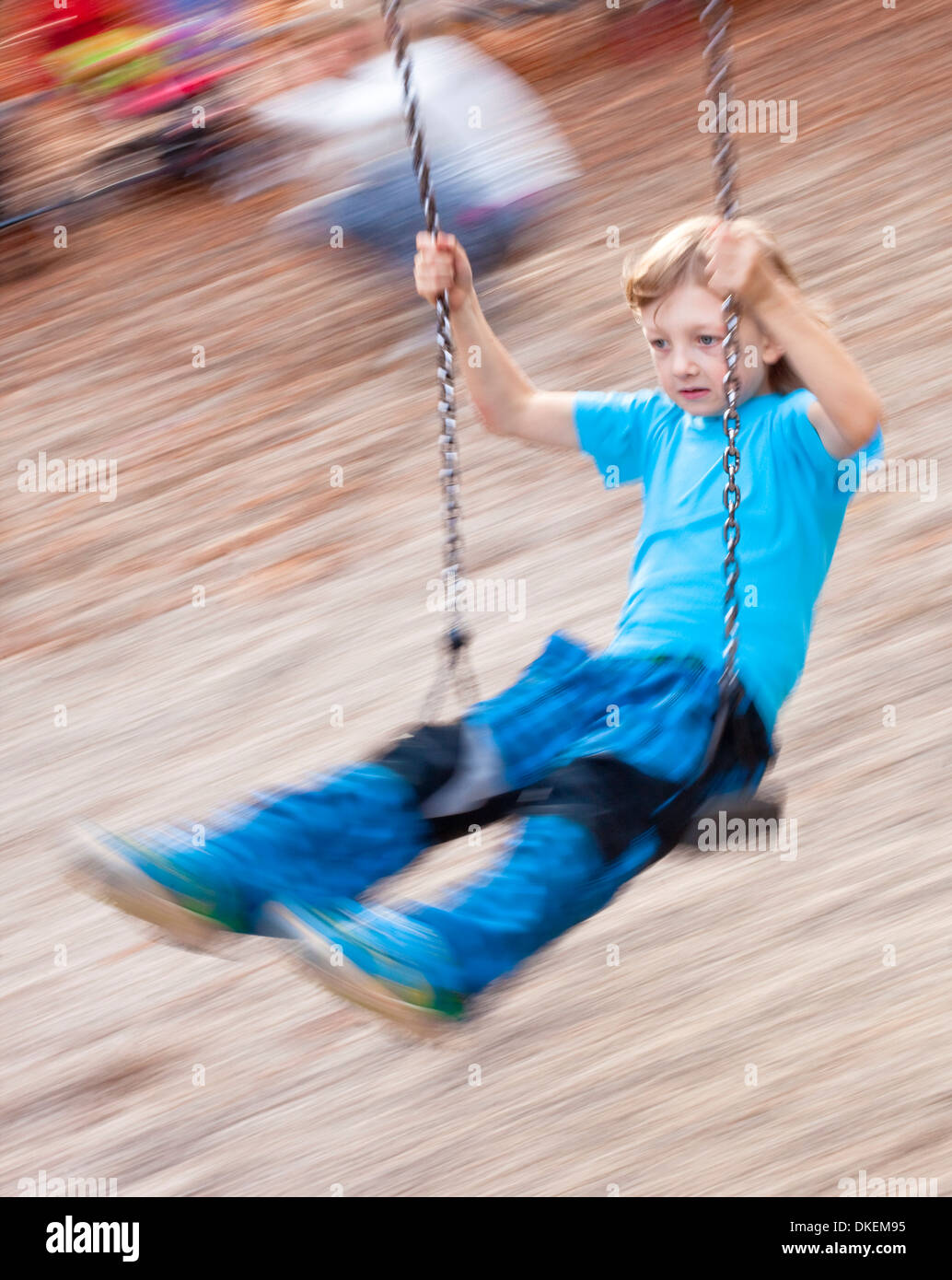Junge auf einer Schaukel auf dem Spielplatz Stockfoto