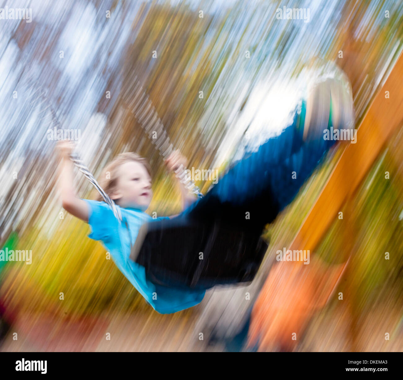 Junge auf einer Schaukel auf dem Spielplatz Stockfoto