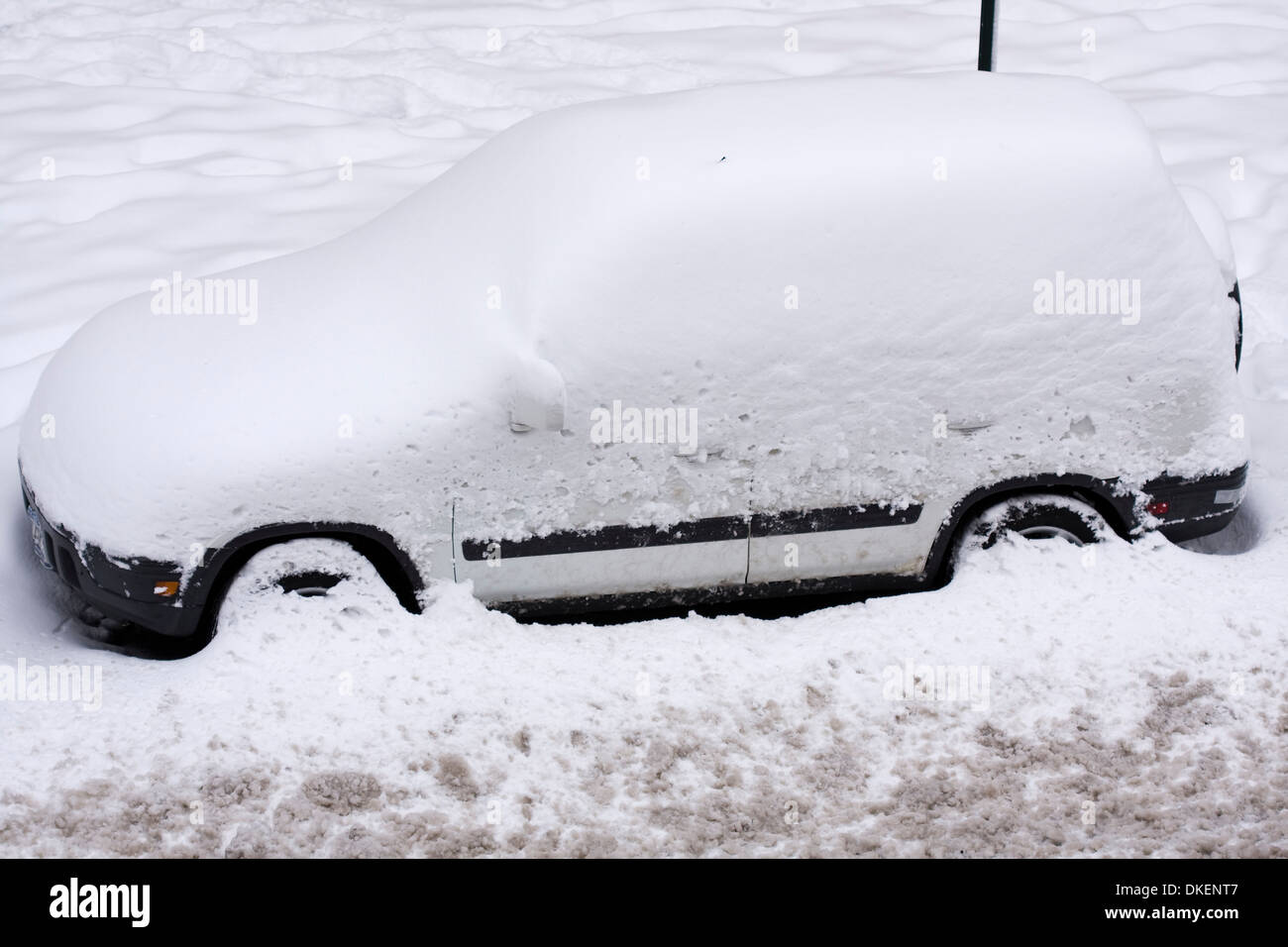 Schneebedeckte Sport Utility Vehicle auf einer Stadtstraße geparkt, nachdem ein Pflug während eines Schneesturms Winter vergangen ist Stockfoto