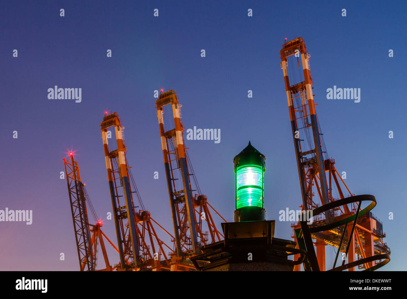 Containerbrücken mit grünen Leuchtfeuer zu Twilght Stunde Stockfoto