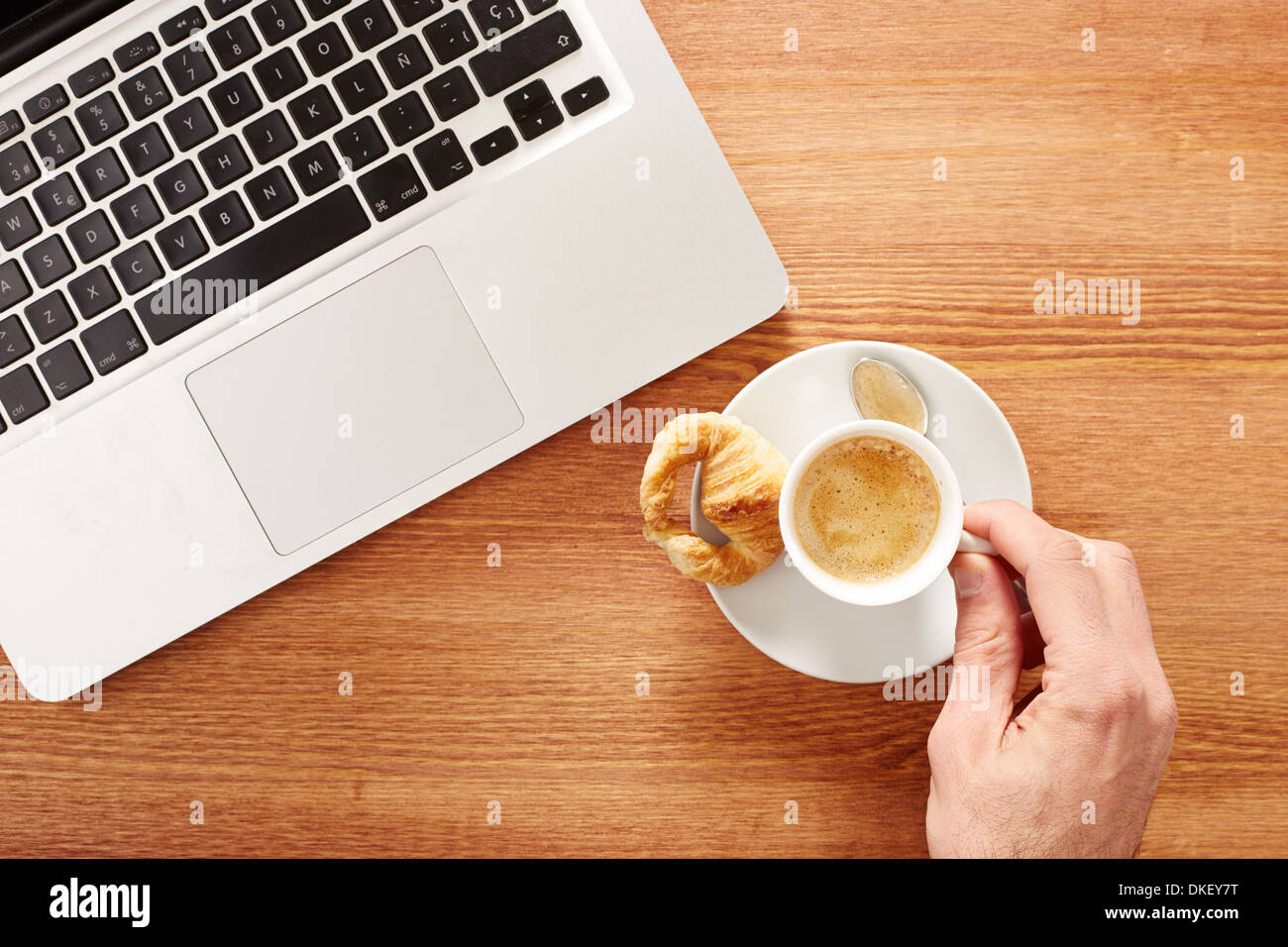 Frühstücken vor Computer am Arbeitsplatz Stockfoto