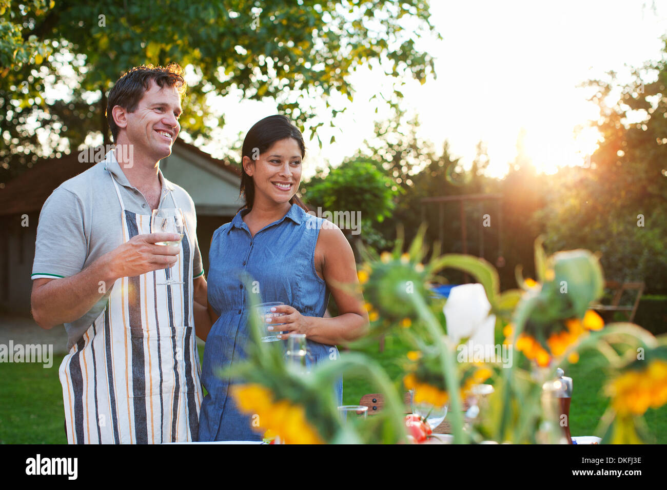 Paar im Garten stehen, Glas Wasser trinken Stockfoto