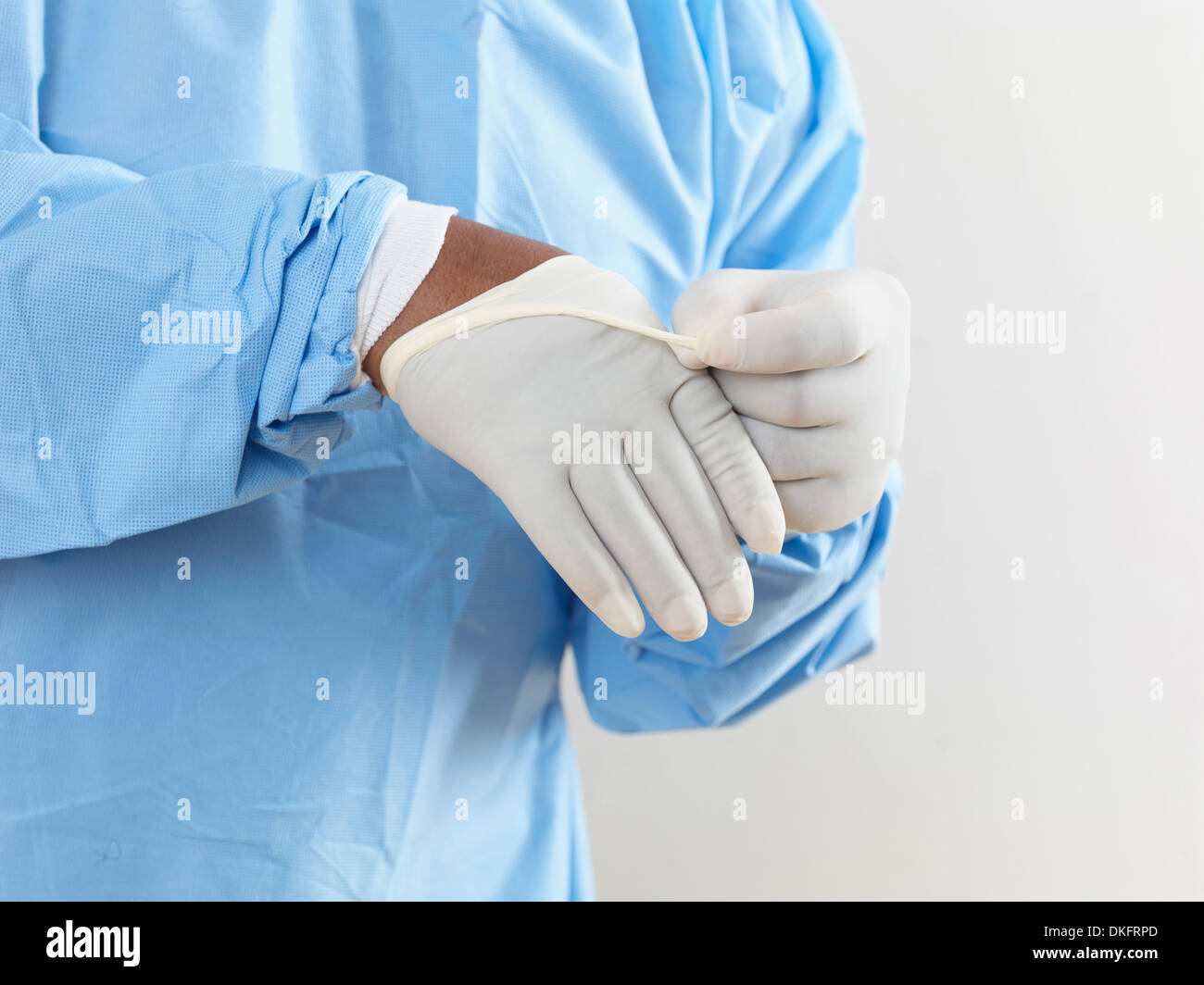 Mittelteil des Chirurgen Scrubs – Die Anfänger tragen chirurgische Latexhandschuhe anziehen Stockfoto