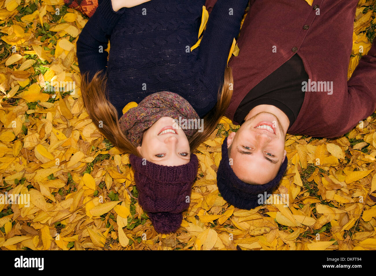 Junges Paar im Herbstlaub liegend Stockfoto
