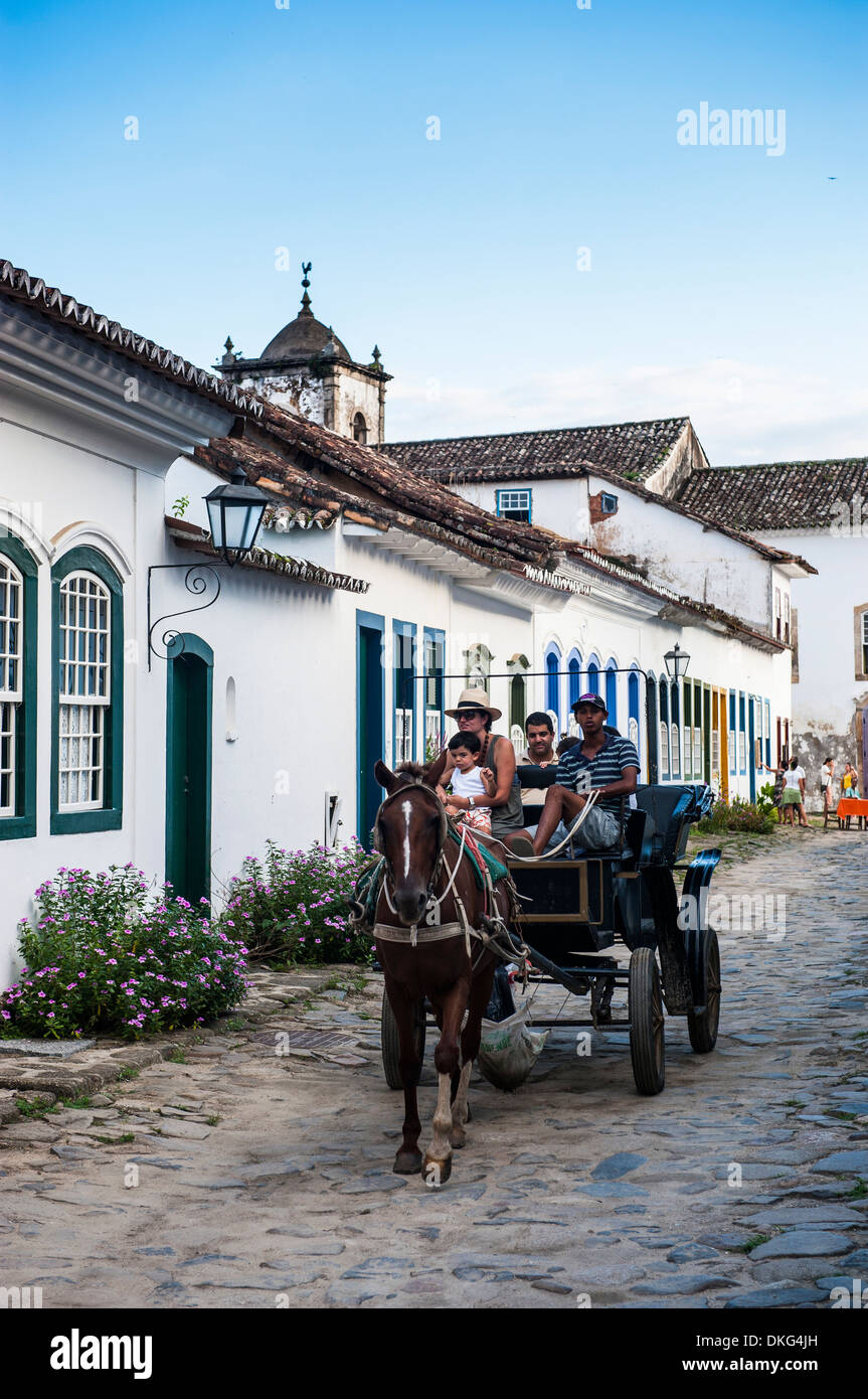Pferdewagen mit Touristen fahren durch die Stadt von Paraty, Rio De Janeiro, Brasilien, Südamerika Stockfoto