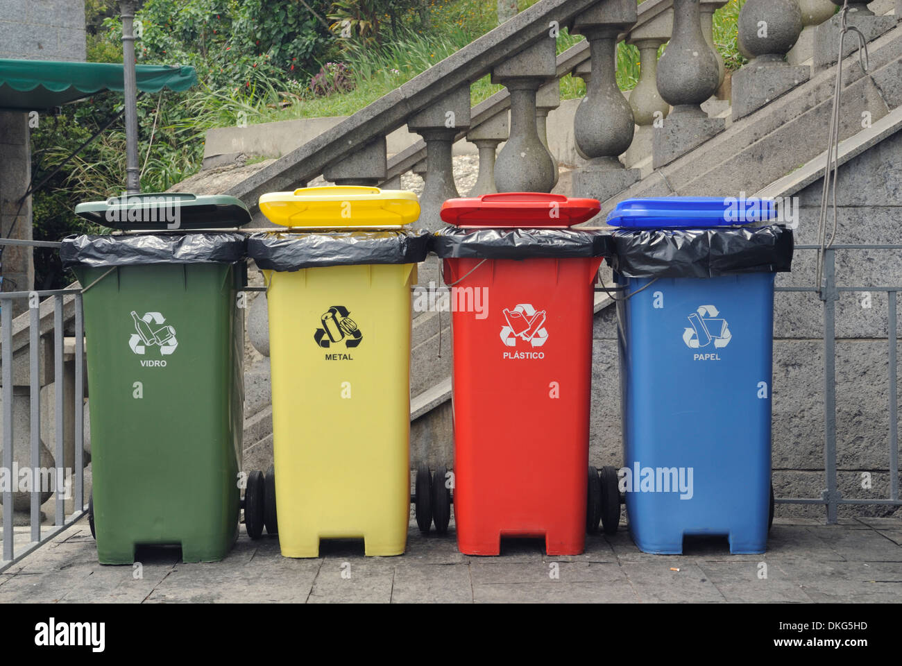 Rio De Janeiro, Brasilien. Vier farbige Abfall Kästen aufgereiht: Glas, Papier, Kunststoff und Metall. Stockfoto