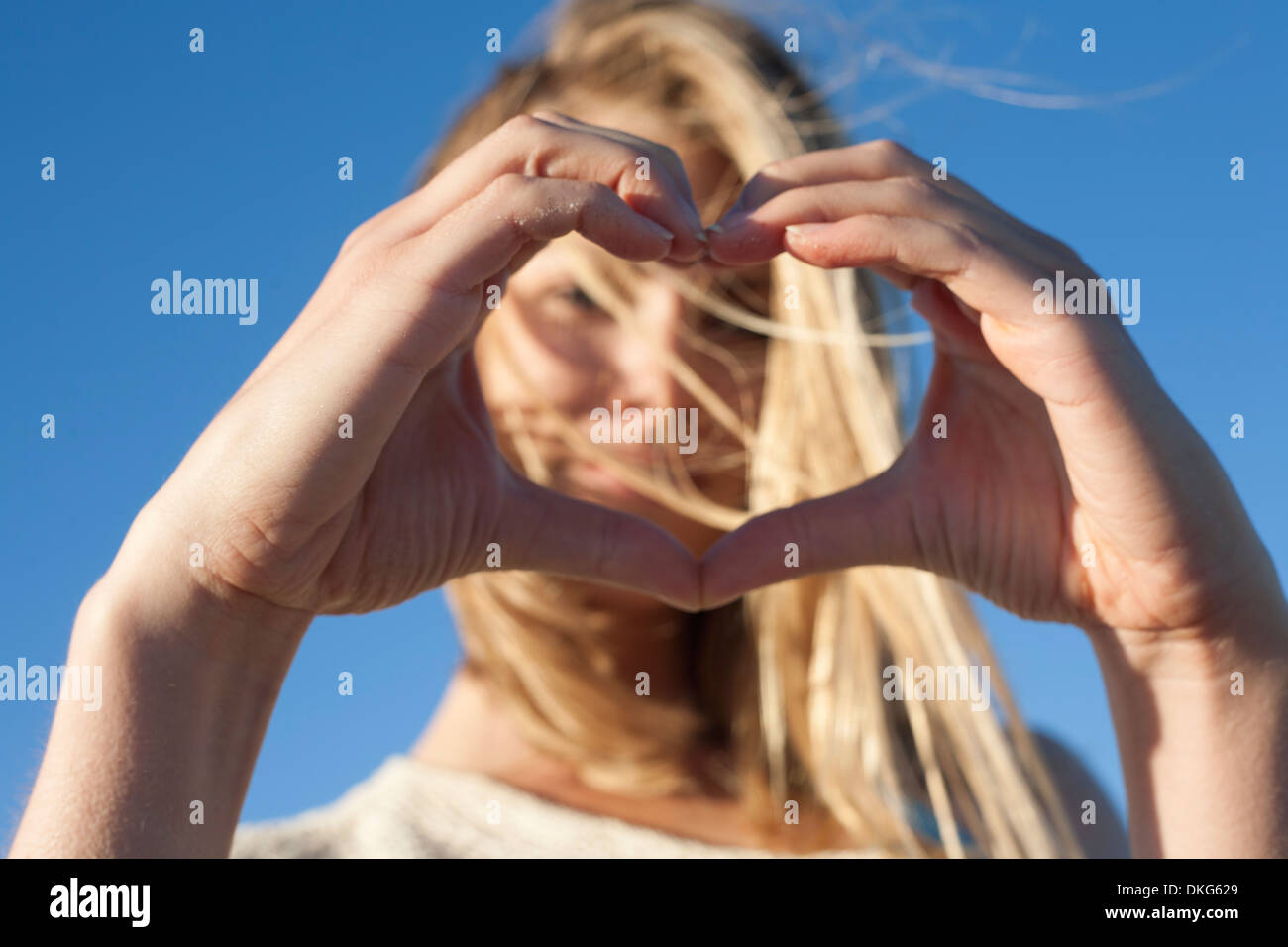 Junge Frau machen Herzschild mit Händen, Breezy Point, Queens, New York, USA Stockfoto